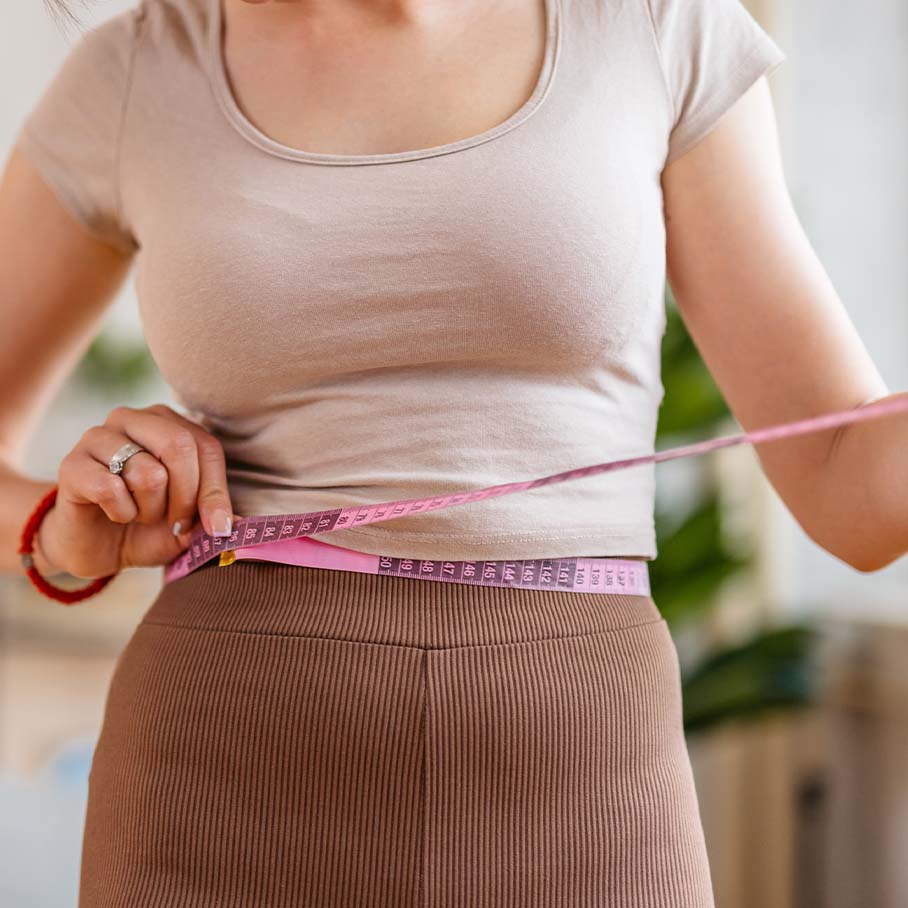 Woman measuring her waist