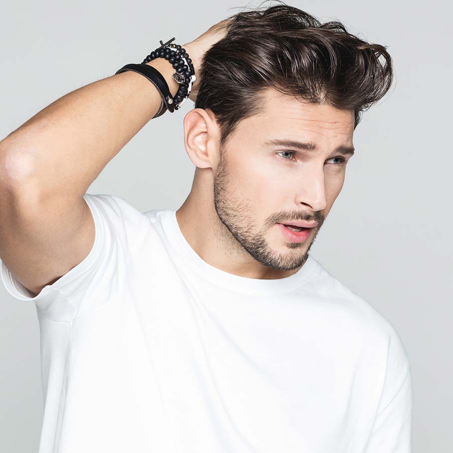 Man touching his hair after hair restoration from Serotonin Centers.