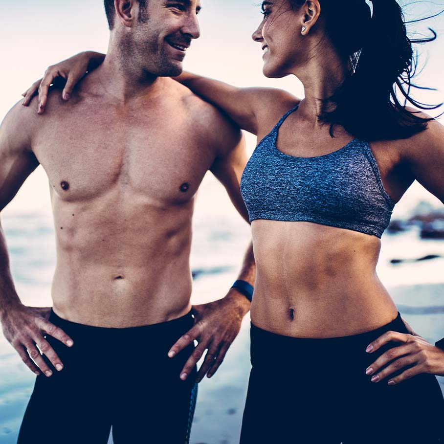 Happy couple at the beach after CoolSculpting from Serotonin Centers.