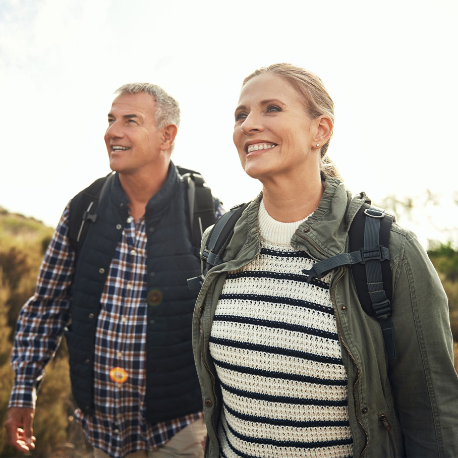 Happy couple hiking after receiving hormone therapy at Serotonin Centers.