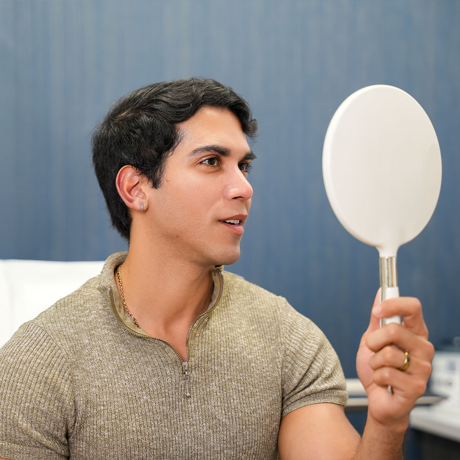 Fort Worth patient examining Sculptra results in the mirror
